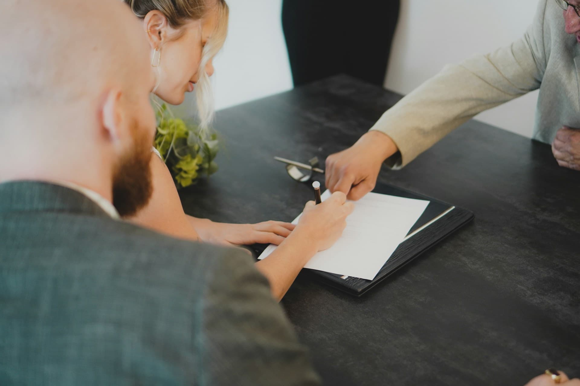 A couple signing their mortgage alongside their adviser